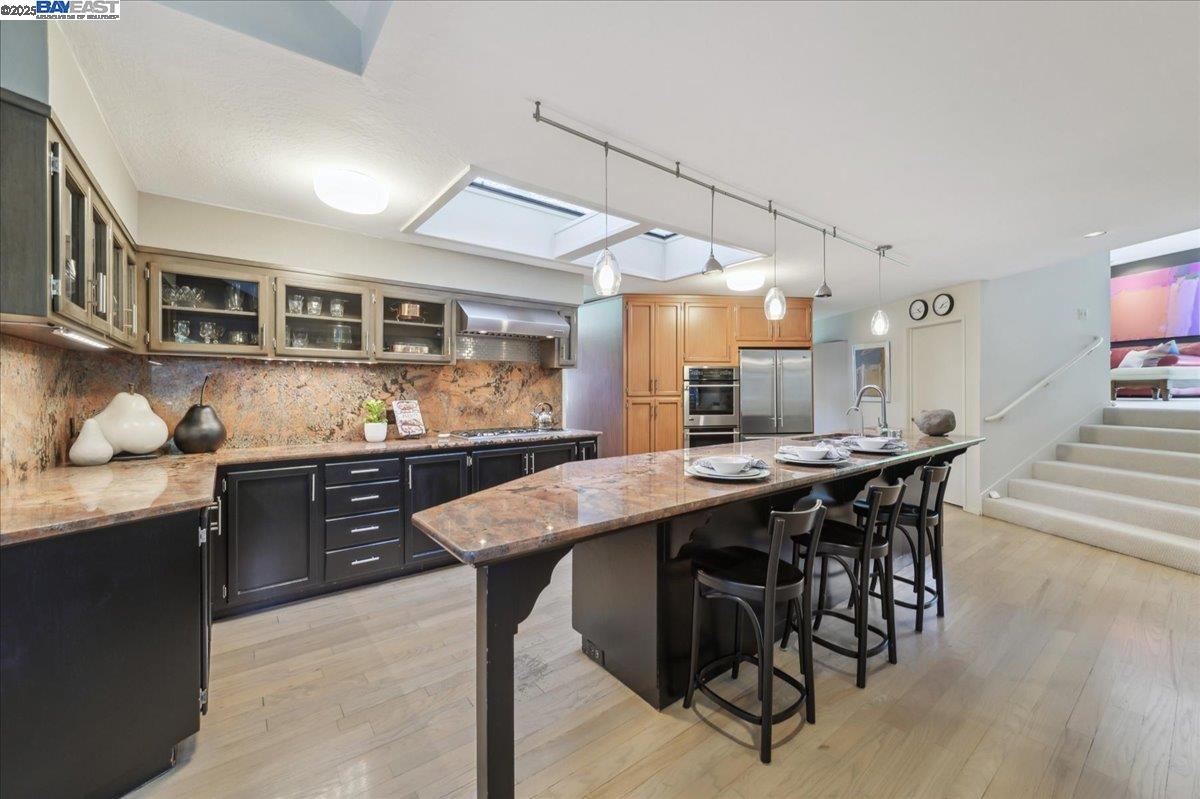 391 Oak Lane Pleasanton, CA 94566 - Photo 26 of 60 a kitchen with granite countertop a table chairs stove and cabinets