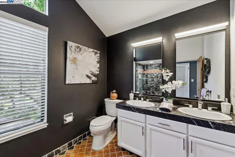 a bedroom with a bed and a dresser next to a window