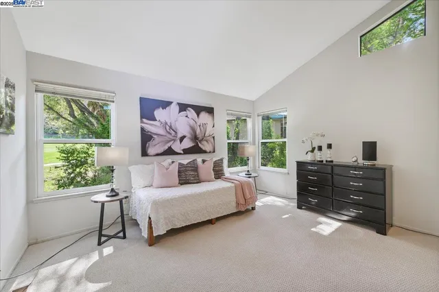 a view of a patio with couches and a table and chairs with wooden floor and fence