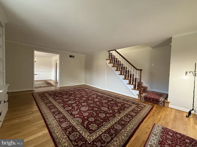 a view of a hallway with wooden floor and rug