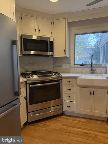 a kitchen with granite countertop a stove microwave and sink