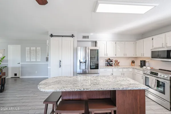 a kitchen with stainless steel appliances granite countertop a stove refrigerator sink and cabinets