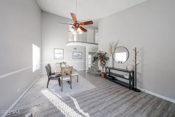 a dining room with chandelier fan and wooden floor