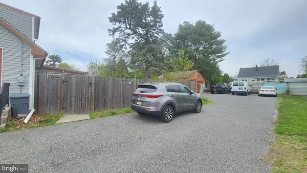 a front view of a house with cars parked on the road