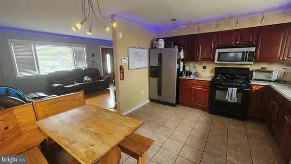 a kitchen with stainless steel appliances granite countertop a refrigerator stove top oven and cabinets