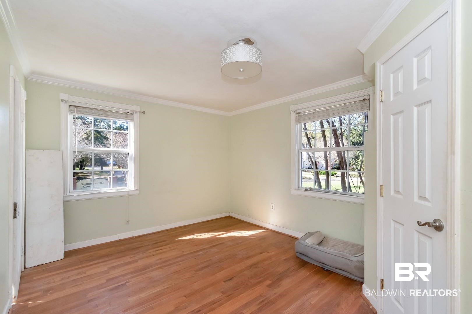 214 Upham Street, Unit 4A Mobile, AL 36607 - Photo 21 of 23 Unfurnished bedroom featuring crown molding, multiple windows, and light wood-type flooring