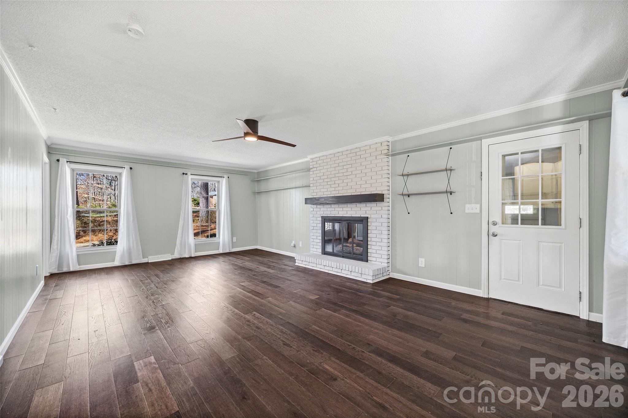 405 Bratton Avenue York, SC 29745 - Photo 7 of 43 an empty room with wooden floor fireplace and windows