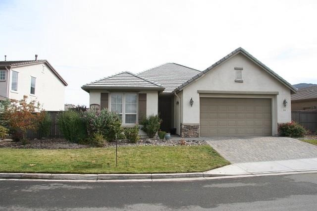 a front view of a house with a garden and garage