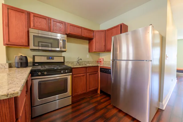 a kitchen with stainless steel appliances granite countertop a refrigerator stove and sink