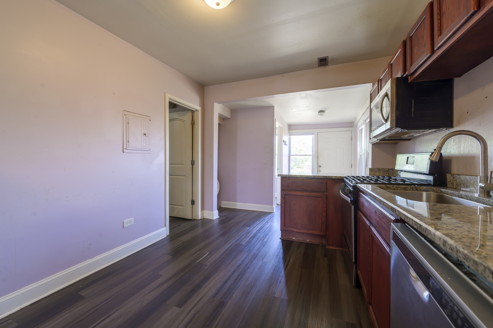 2436 West Fillmore Street Chicago, IL 60612 - Photo 26 of 44 a kitchen with granite countertop wooden floors and stainless steel appliances