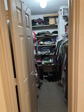 a view of walk in closet with clothes and shoes