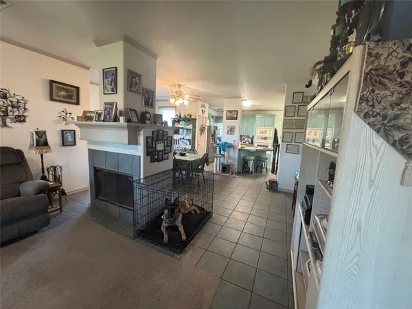 a room with furniture a flat screen tv and kitchen view