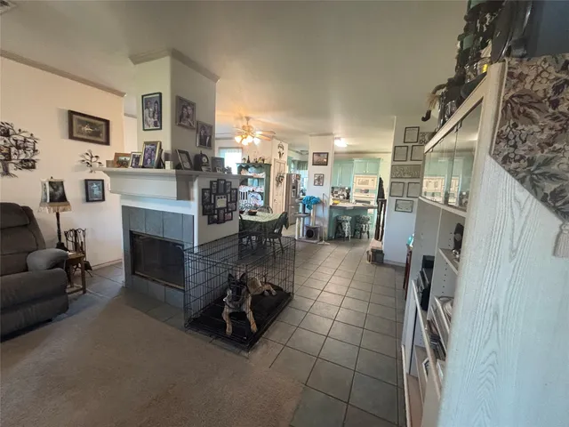 a room with furniture a flat screen tv and kitchen view