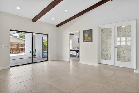 a view of an empty room with window and bathroom