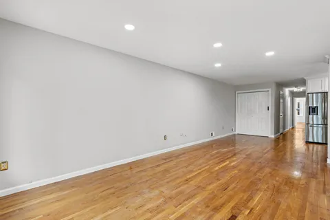 a view of empty room with wooden floor