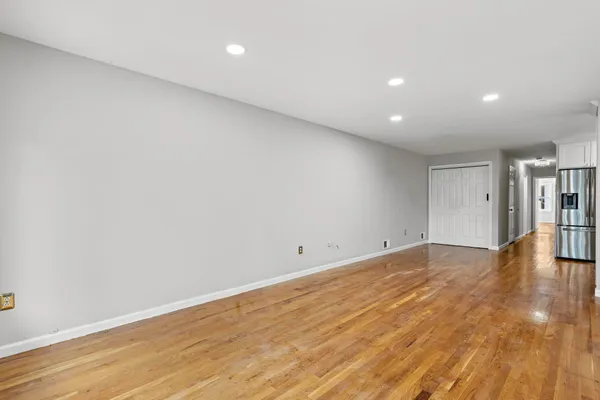 a view of empty room with wooden floor