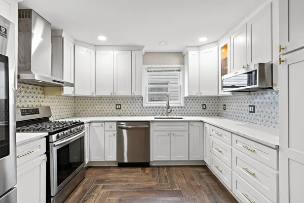 a kitchen with stainless steel appliances granite countertop a stove sink and cabinets