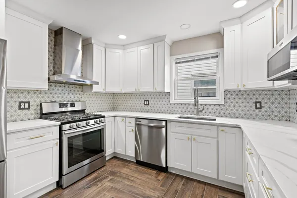 a kitchen with stainless steel appliances granite countertop a stove sink and cabinets