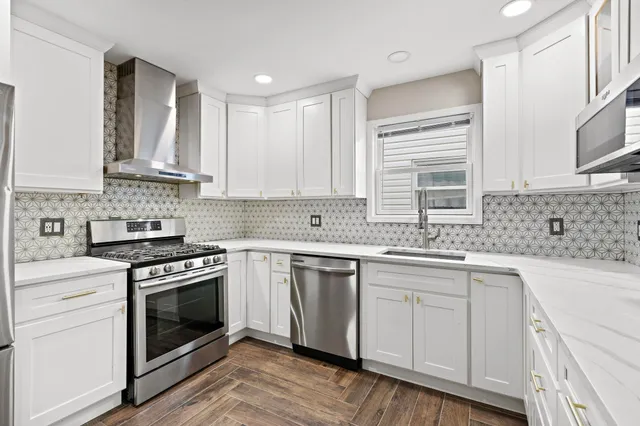 a kitchen with stainless steel appliances granite countertop a stove sink and cabinets