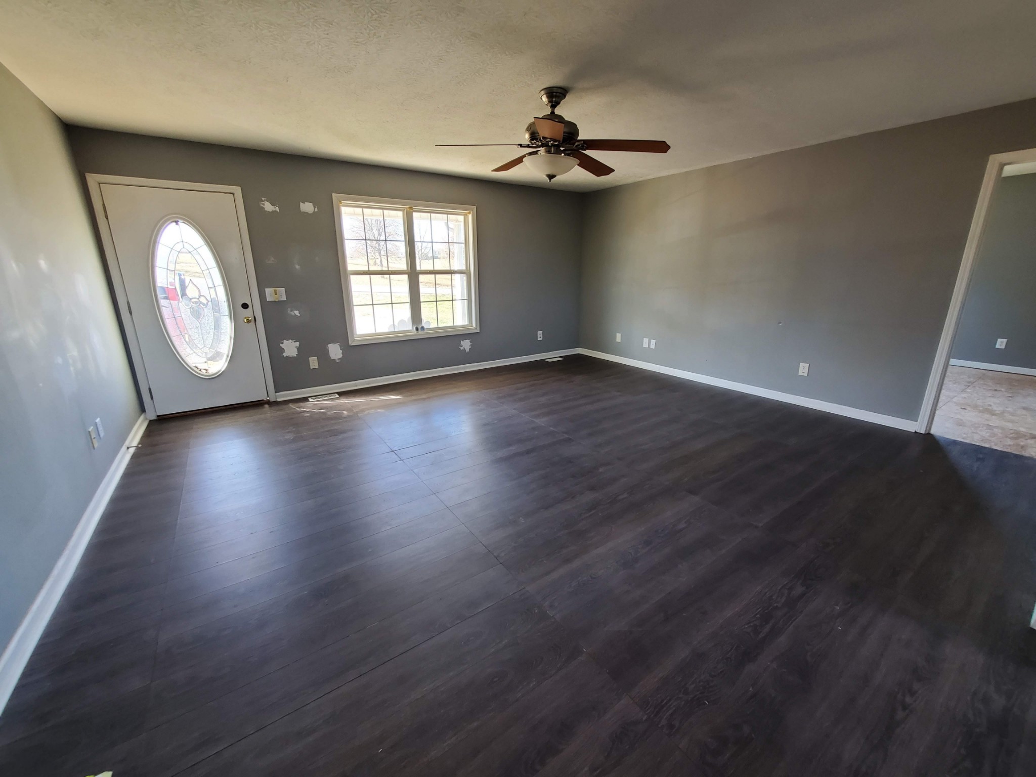 573 Womack Road Bethpage, TN 37022 - Photo 3 of 21 an empty room with wooden floor cabinet and windows