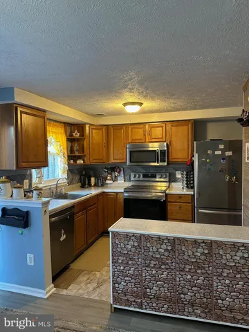 a kitchen with stainless steel appliances granite countertop a stove sink and cabinets