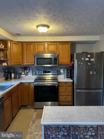 a kitchen with a refrigerator sink and stove top oven