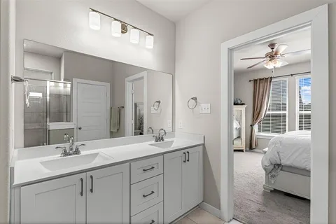 a spacious bathroom with a double vanity sink a large mirror and a bathtub