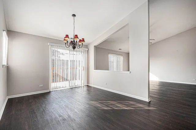 a view of a room with wooden floor chandelier and entryway
