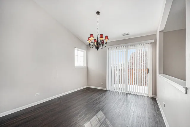 a view of a livingroom with wooden floor and a chandelier