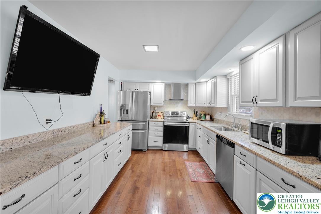 501 Creek Road Bath, PA 18014 - Photo 12 of 50 a large kitchen with stainless steel appliances granite countertop a stove a sink and a microwave