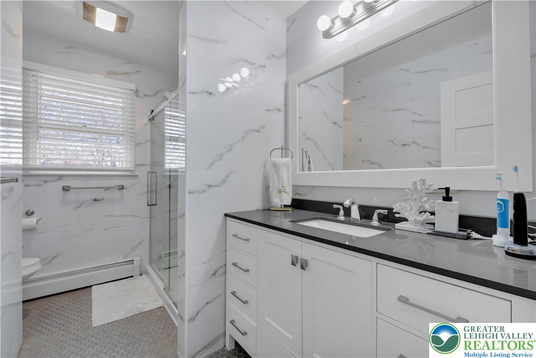 501 Creek Road Bath, PA 18014 - Photo 17 of 50 a bathroom with a granite countertop sink a mirror a vanity and a shower
