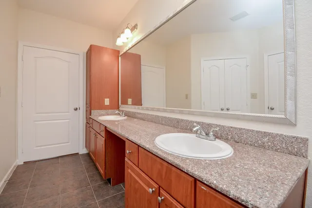 a bathroom with a granite countertop sink and a mirror