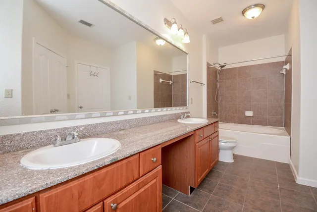a bathroom with a granite countertop sink double mirror bathtub and shower