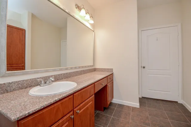 a bathroom with a granite countertop sink and a mirror