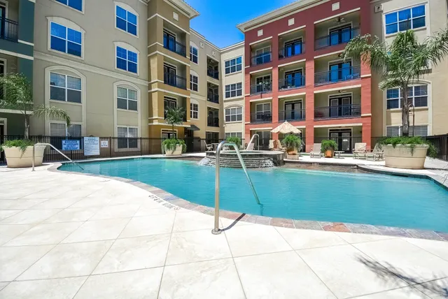 a front view of a building with a garden and sitting area