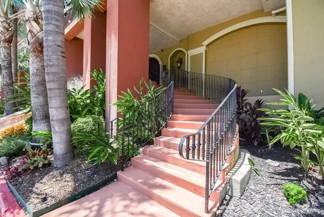 a view of a house with a yard and potted plants