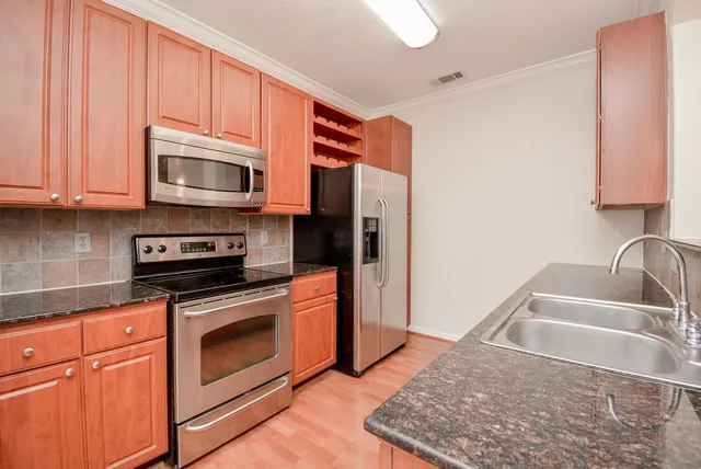 a kitchen with stainless steel appliances granite countertop a sink stove and microwave