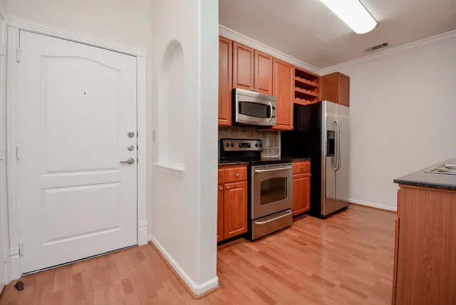 a kitchen with stainless steel appliances a stove a refrigerator and cabinets