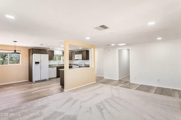 a view of a kitchen with refrigerator and white cabinets