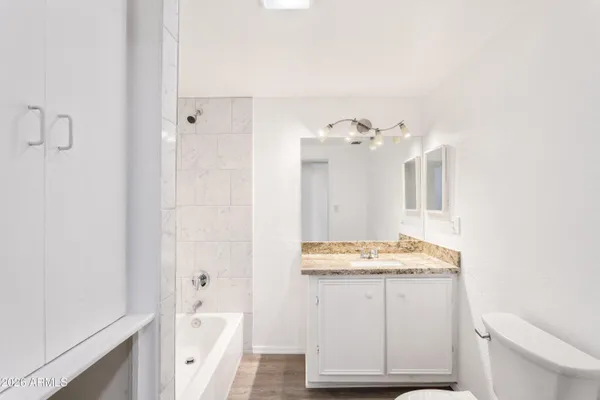 a bathroom with a granite countertop sink and shower