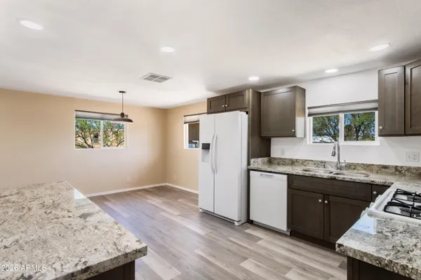 a kitchen with stainless steel appliances granite countertop a sink stove and refrigerator