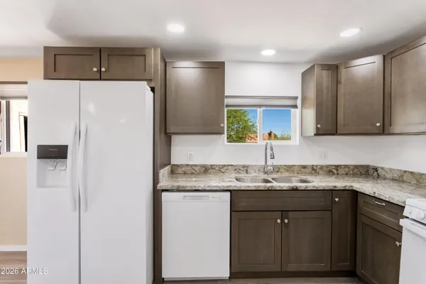 a kitchen with kitchen island granite countertop a sink stove and refrigerator