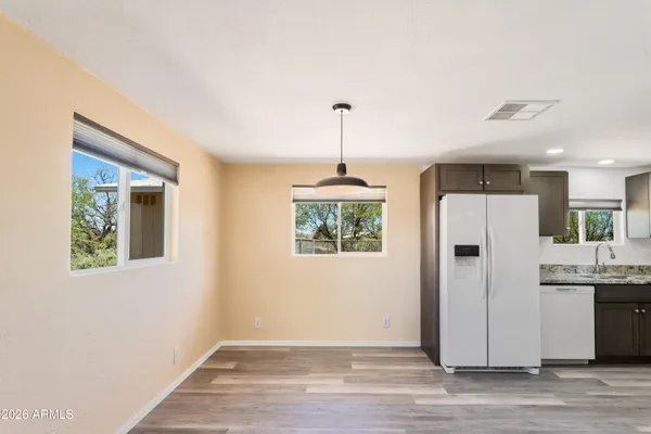 a view of a kitchen with a refrigerator wooden floor and a ceiling fan