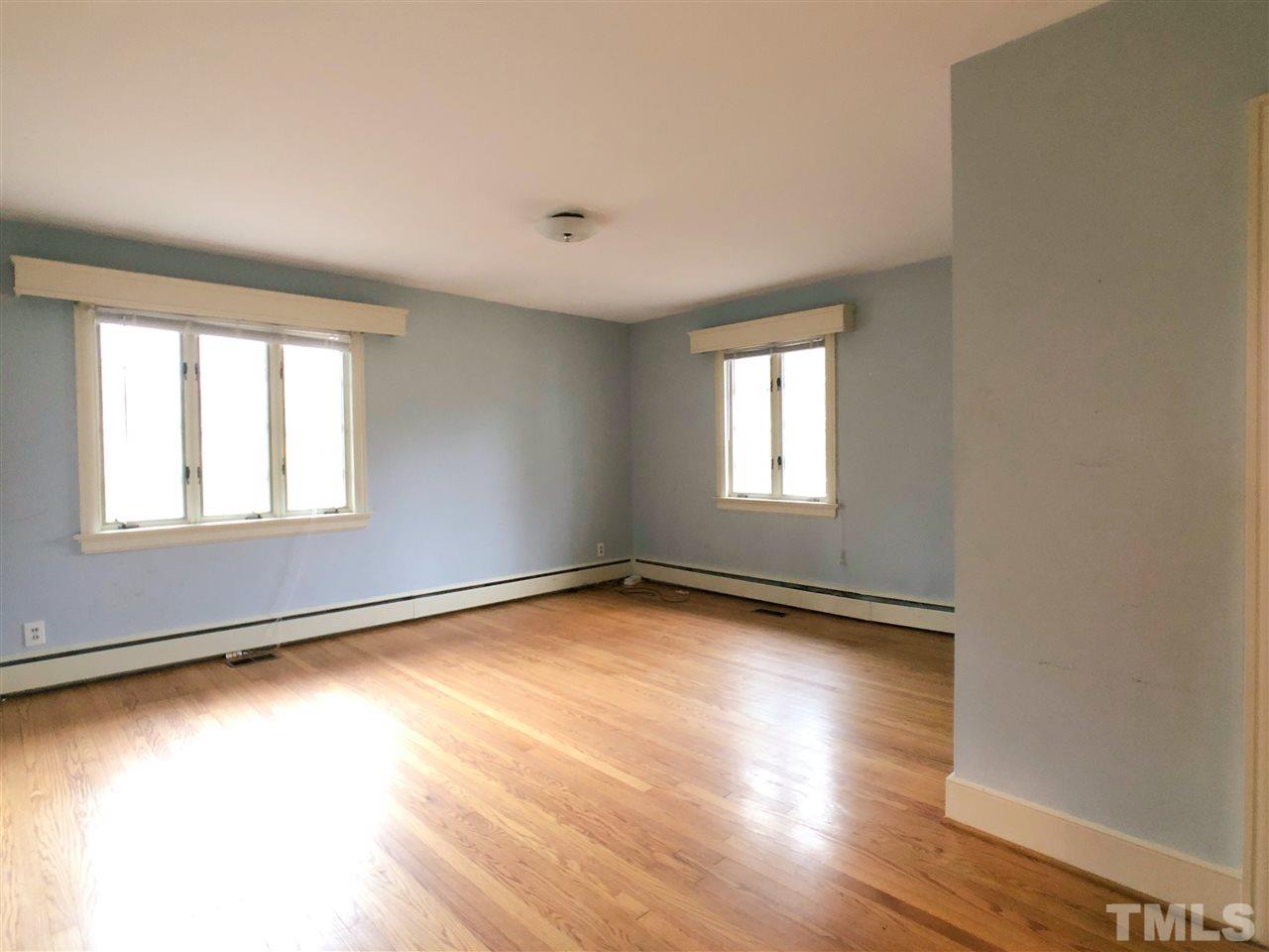 814 Woodburn Road Raleigh, NC 27605 - Photo 8 of 12 an empty room with wooden floor and windows