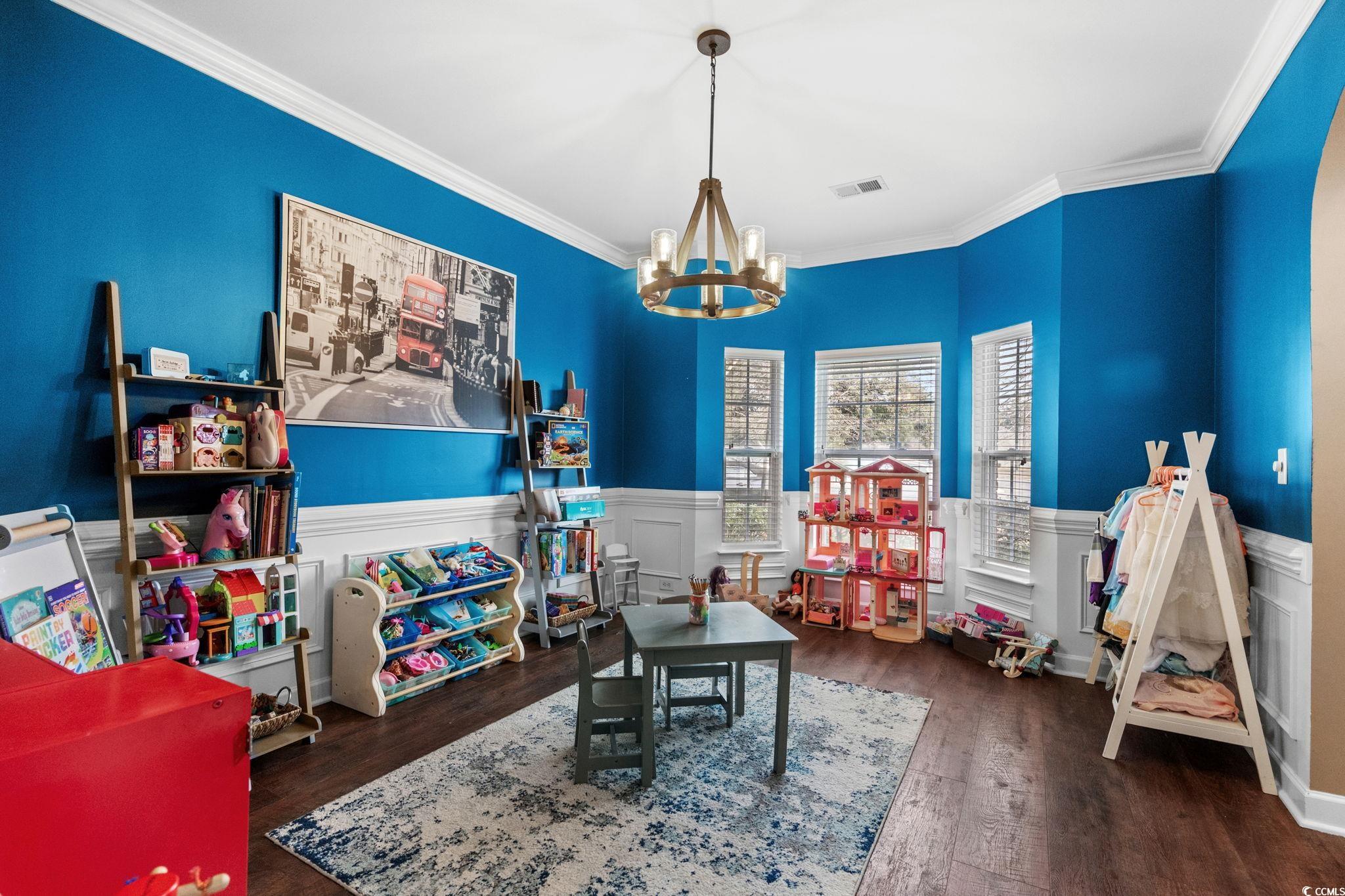 318 Barlow Court Conway, SC 29526 - Photo 12 of 36 Formal dining room featuring a wainscoted wall, a decorative wall, dark wood-style floors, a chandelier, and ornamental molding