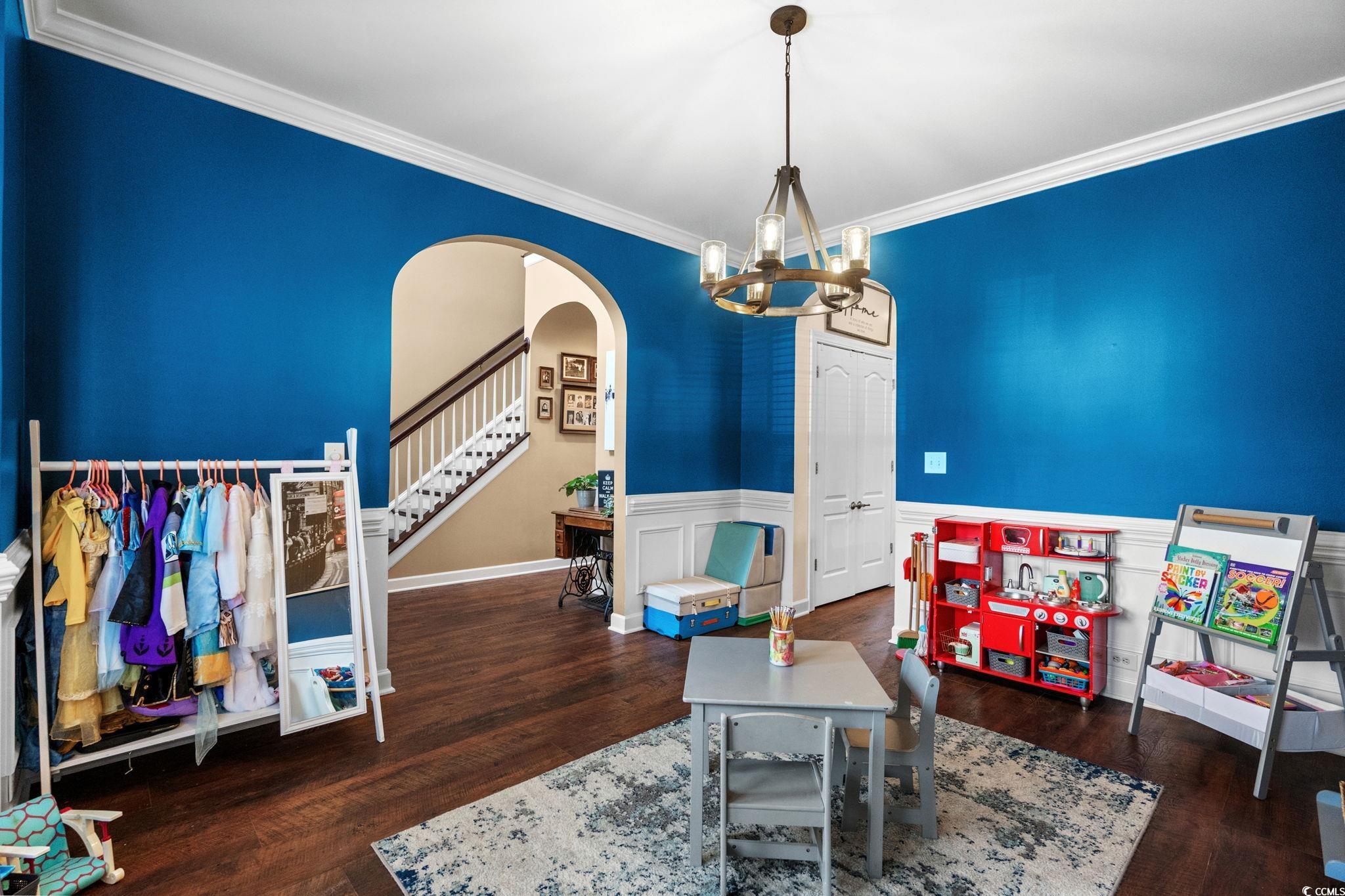 318 Barlow Court Conway, SC 29526 - Photo 13 of 36 Formal dining room with arched walkways, a wainscoted wall, dark wood-type flooring, crown molding, and a chandelier