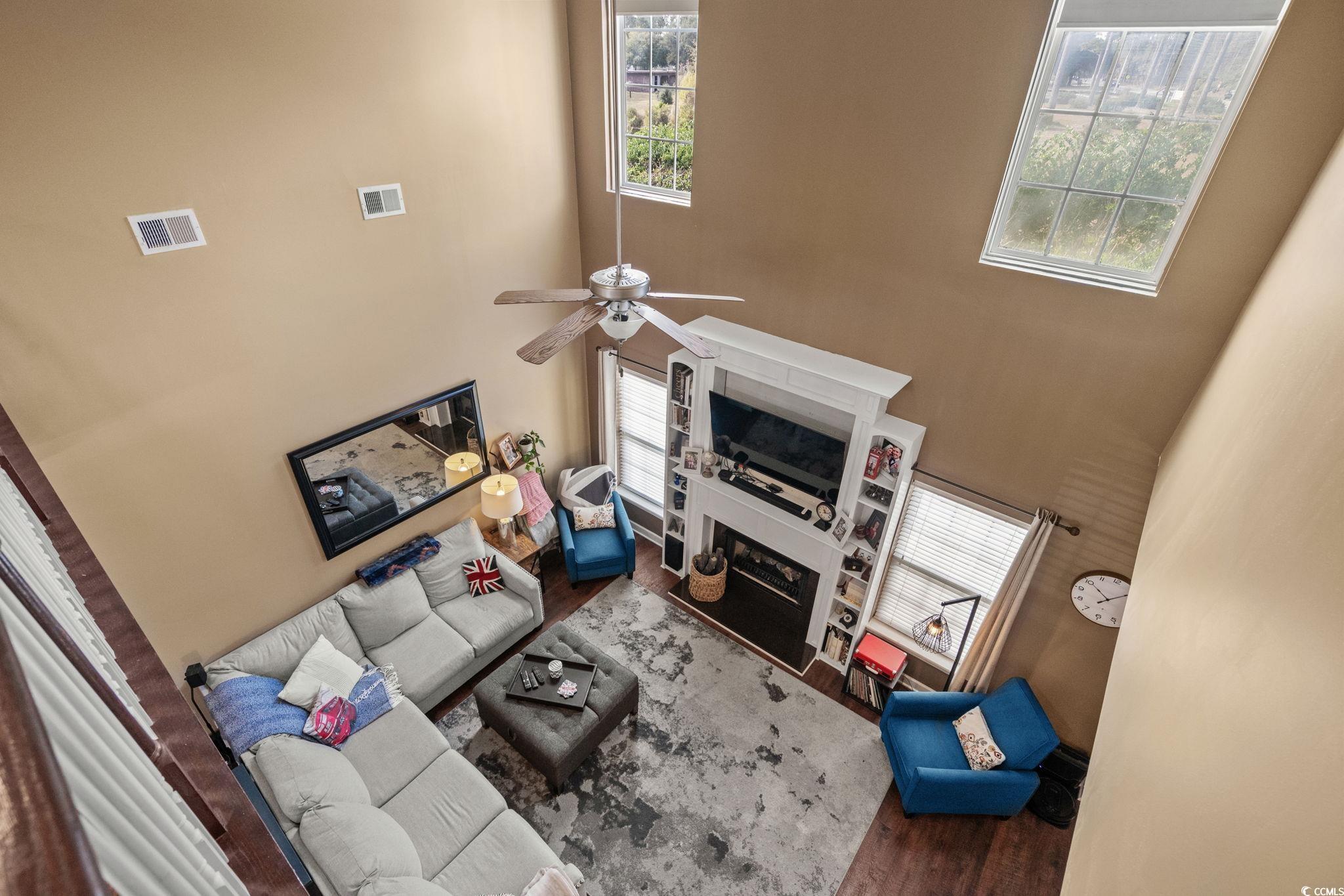318 Barlow Court Conway, SC 29526 - Photo 18 of 36 Living area with a towering ceiling, wood finished floors, a glass covered fireplace, and ceiling fan