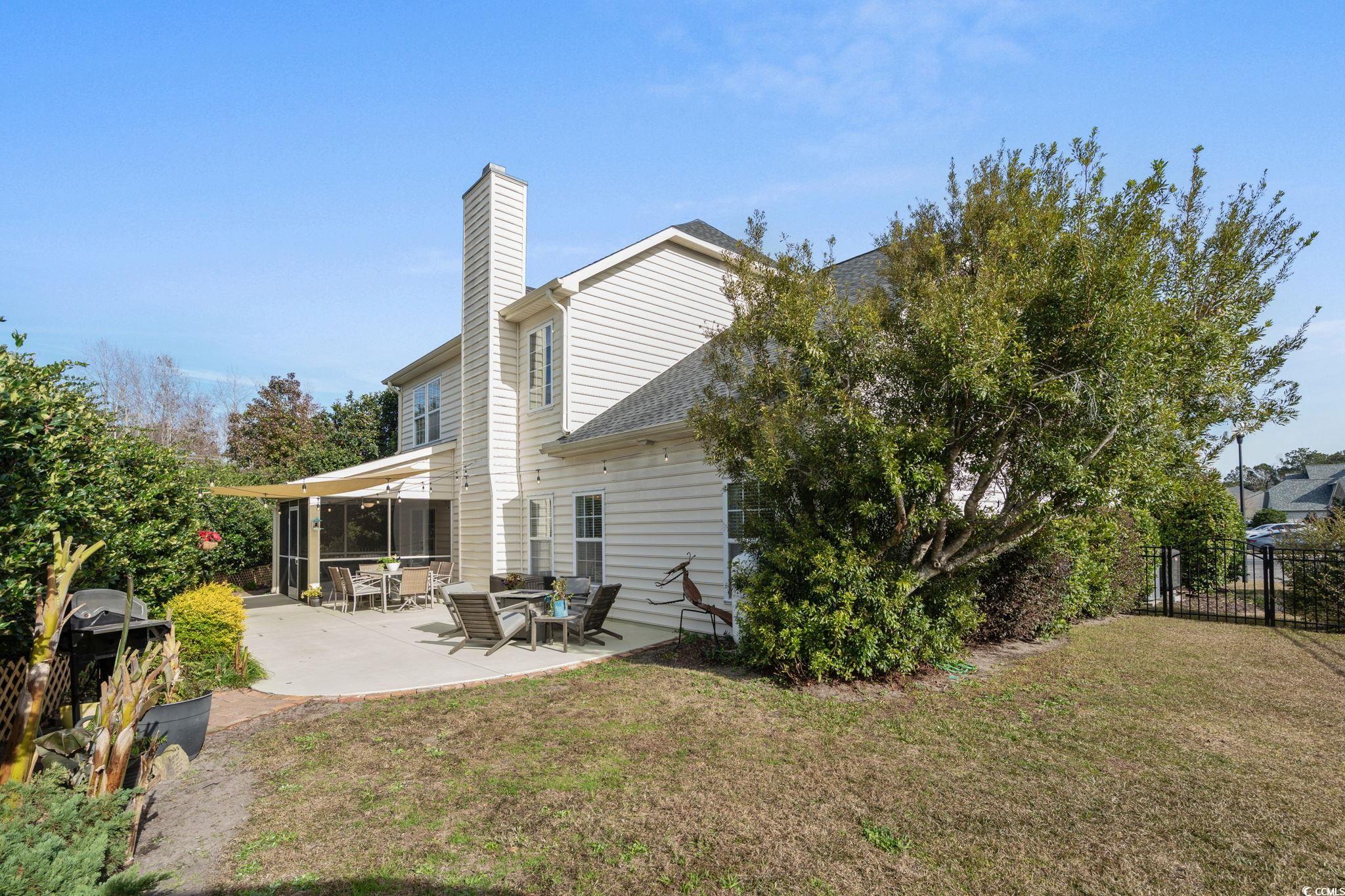 318 Barlow Court Conway, SC 29526 - Photo 29 of 36 Back of property featuring a sunroom, a patio area, a chimney, and a shingled roof
