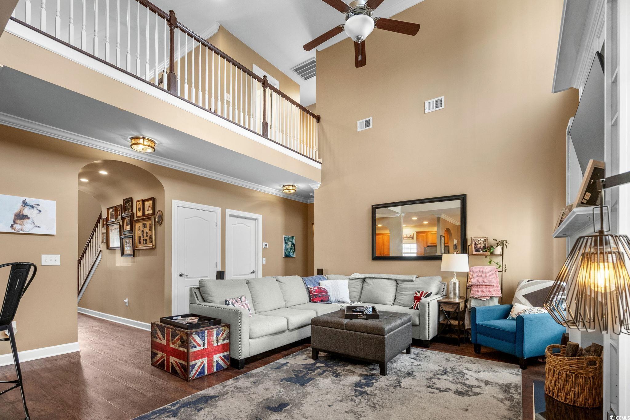 318 Barlow Court Conway, SC 29526 - Photo 7 of 36 Living room featuring arched walkways, dark wood-type flooring, crown molding, a towering ceiling, and a ceiling fan