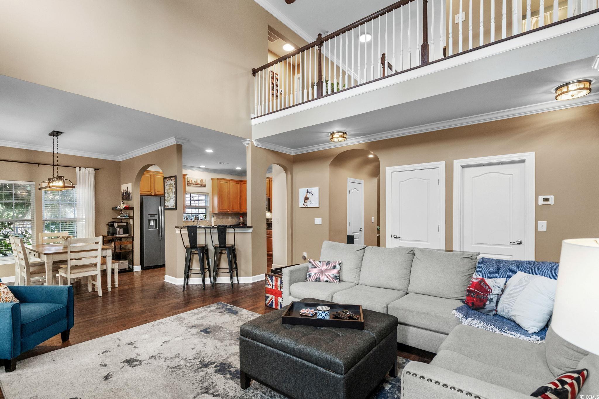 318 Barlow Court Conway, SC 29526 - Photo 8 of 36 Living room with ornamental molding, arched walkways, dark wood-type flooring, a towering ceiling, and recessed lighting